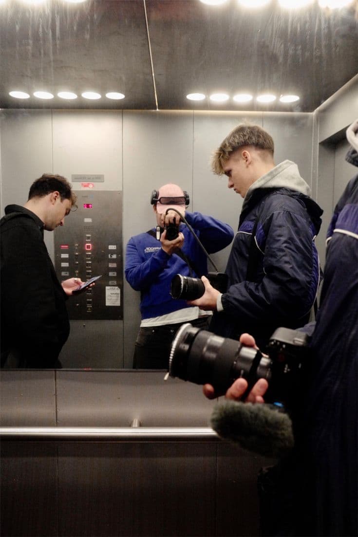 Team in elevator with camera gear